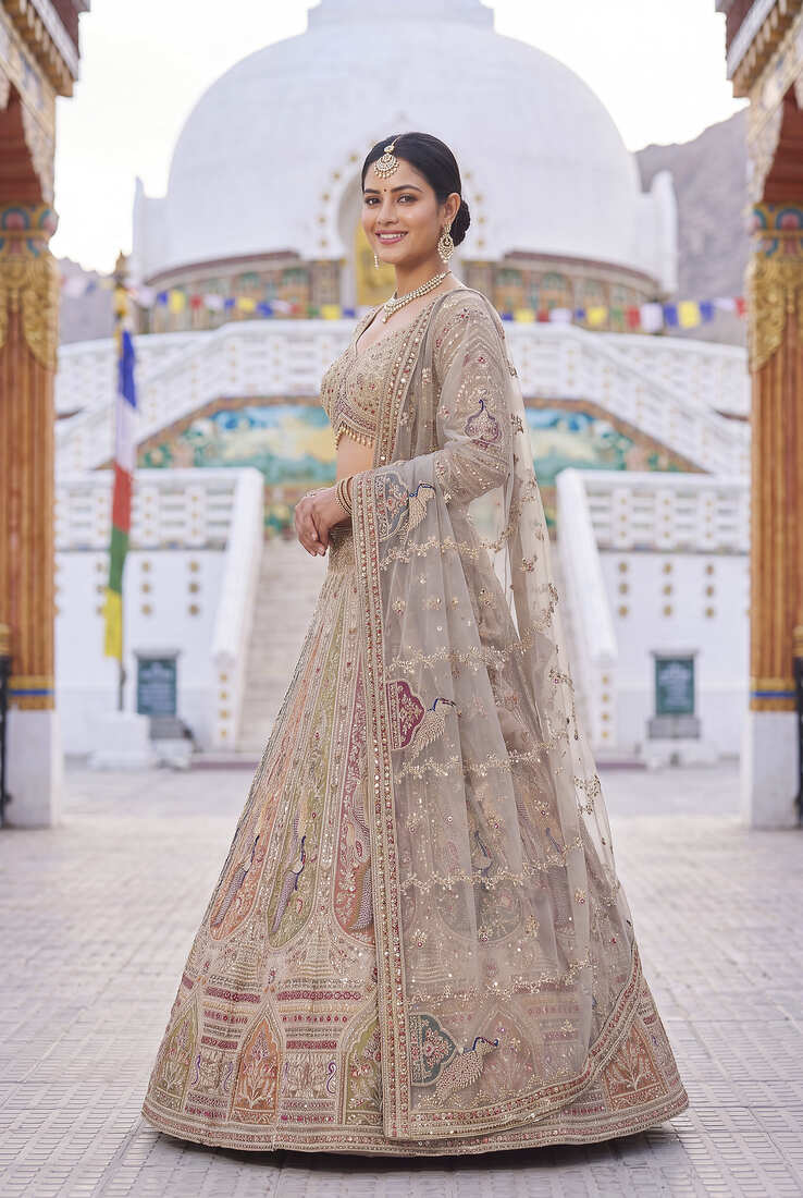 Elegant Beige Bridal Lehenga Set Featuring Traditional Peacock Motifs and Intricate Hand Embroidery